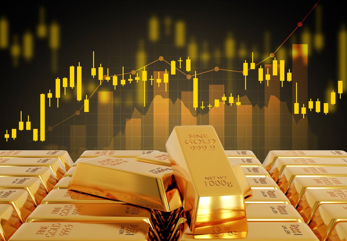 Gold bars beside a rising market chart